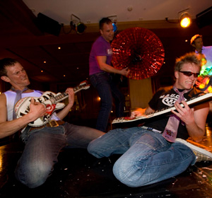 Künstler mit Luftgitarren auf der Bühne.
