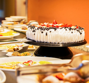 Sahnetorte inmitten eines Buffets.
